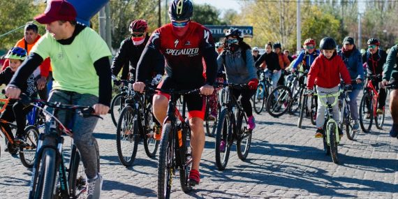 Dynamic group bicycle race in urban area, showcasing diverse cyclists enjoying a sunny day.